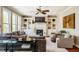 Comfortable living space featuring built-in bookshelves, a fireplace, ceiling fan, and a plush grey sofa at 658 Bennett Mountain Trce, Chapel Hill, NC 27516