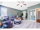 Inviting living room with a large couch, a ceiling fan, a built-in desk and shelving, and a French door at 658 Bennett Mountain Trce, Chapel Hill, NC 27516