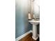 Charming powder room features a classic pedestal sink and decorative mirror, creating a refined space at 658 Bennett Mountain Trce, Chapel Hill, NC 27516