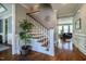 Elegant staircase with hardwood steps, white banisters, decorative accents, and an inviting view into the living room at 658 Bennett Mountain Trce, Chapel Hill, NC 27516
