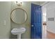 Charming bathroom with pedestal sink, blue accent door and decorative round mirror at 703 Copperline Dr # 301, Chapel Hill, NC 27516
