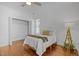 Bright bedroom featuring wood flooring, a closet, a ceiling fan, and a bed with a throw blanket at 703 Copperline Dr # 301, Chapel Hill, NC 27516