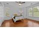 Bright bedroom with wood floors, ceiling fan, and natural light from multiple windows at 703 Copperline Dr # 301, Chapel Hill, NC 27516