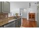 Open-concept kitchen with granite countertops, tile backsplash, stainless steel appliances, and wood floors at 703 Copperline Dr # 301, Chapel Hill, NC 27516