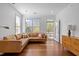 Well-lit living room featuring a leather sectional, a cabinet, hardwood floors, and a door to the balcony at 703 Copperline Dr # 301, Chapel Hill, NC 27516
