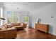 Cozy living room with hardwood floors, a leather sectional, a modern cabinet, and a bright window at 703 Copperline Dr # 301, Chapel Hill, NC 27516