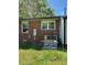 Side view of a brick house with an air conditioning unit outside at 706 Orchard Dr, Graham, NC 27253