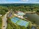 Aerial view of a beautiful community lake featuring a pool, tennis courts, and playground at 707 Southshore Pkwy, Durham, NC 27703