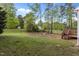 A view from a backyard featuring a lush green lawn and mature trees at 707 Southshore Pkwy, Durham, NC 27703