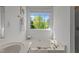 Bathroom featuring a soaking tub with a large window overlooking a scenic view at 707 Southshore Pkwy, Durham, NC 27703