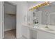 Bathroom featuring dual sinks, a large mirror, decorative lighting, and a walk-in closet at 707 Southshore Pkwy, Durham, NC 27703