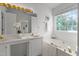 Bright bathroom with dual sinks, a soaking tub, and a large window providing natural light at 707 Southshore Pkwy, Durham, NC 27703