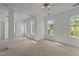 Spacious bedroom with neutral carpet, white walls, a ceiling fan, and multiple windows at 707 Southshore Pkwy, Durham, NC 27703