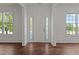 Bright foyer with elegant trim, beautiful hardwood floors, and a welcoming front door flanked by sidelight windows at 707 Southshore Pkwy, Durham, NC 27703