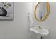 Simple half bathroom featuring a pedestal sink, gold hardware and a gold framed mirror at 707 Southshore Pkwy, Durham, NC 27703