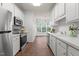 Bright kitchen with white cabinets, stainless steel appliances, and tile flooring at 707 Southshore Pkwy, Durham, NC 27703