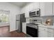 Kitchen with white cabinets, stainless steel appliances, and a view to the sunroom at 707 Southshore Pkwy, Durham, NC 27703
