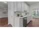 Galley kitchen featuring white cabinetry and stainless steel dishwasher at 707 Southshore Pkwy, Durham, NC 27703