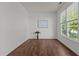Home office with hardwood floors, ample natural light from a large window, and a minimalist decor for a serene workspace at 707 Southshore Pkwy, Durham, NC 27703