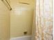 Yellow-tiled bathtub with shower, featuring neutral shower curtain and vintage fixtures at 713 Macon Pl, Raleigh, NC 27609