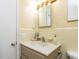 A vintage bathroom has a pale yellow vanity, patterned wallpaper, and traditional fixtures at 713 Macon Pl, Raleigh, NC 27609