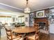 Charming dining room with a brick fireplace, hardwood floors, and views into the living room at 713 Macon Pl, Raleigh, NC 27609