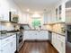 Modern kitchen with white cabinetry, granite countertops, and stainless steel appliances at 713 Macon Pl, Raleigh, NC 27609