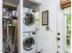 Convenient laundry area with stacked washer and dryer and storage shelves at 713 Macon Pl, Raleigh, NC 27609