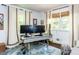 Bright office space featuring large windows, neutral curtains, and a stylish gray desk at 713 Macon Pl, Raleigh, NC 27609