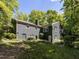 View of the rear exterior featuring a dark brick, a well-maintained yard, and mature trees at 713 Macon Pl, Raleigh, NC 27609