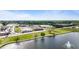 Aerial view of a scenic pond with a fountain, greenery, buildings, and a commercial area at 72 S Grey Abbey Dr, Clayton, NC 27527