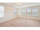 Cozy bedroom with three windows and neutral carpet and walls at 72 S Grey Abbey Dr, Clayton, NC 27527