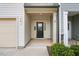 Inviting front entrance with a beige garage door, neutral siding and classic black front door at 72 S Grey Abbey Dr, Clayton, NC 27527