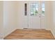 Bright foyer featuring a white door with glass panels, wood-look floors, and fresh paint at 72 S Grey Abbey Dr, Clayton, NC 27527