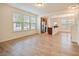 Open-concept living space with wood-look floors, large windows, and seamless flow to the kitchen at 72 S Grey Abbey Dr, Clayton, NC 27527