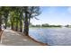 Scenic view of a serene pond lined with lush trees and a paved walkway at 72 S Grey Abbey Dr, Clayton, NC 27527
