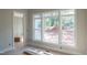Bright room featuring a large window with view of tree-lined backyard, green wall and white wainscoting and trim at 7301 Wexford Woods Ln, Wake Forest, NC 27587