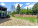 A lush, green backyard with a retaining wall and mature trees providing ample privacy at 7510 Latteri Ct, Raleigh, NC 27613