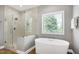 Bright bathroom featuring a soaking tub and glass shower with modern fixtures at 7510 Latteri Ct, Raleigh, NC 27613