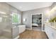 Well-lit bathroom with soaking tub, glass shower, double vanity and views into the bedroom area at 7510 Latteri Ct, Raleigh, NC 27613