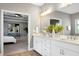 Bright bathroom features a double vanity, large mirror, and stylish decor with views into the main bedroom at 7510 Latteri Ct, Raleigh, NC 27613