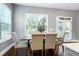 Well-lit dining room with large windows, wooden table, and upholstered chairs for a comfortable meal setting at 7510 Latteri Ct, Raleigh, NC 27613