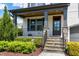 Inviting front porch with stone pillars, manicured landscaping, and a stylish front door at the home's entry at 7510 Latteri Ct, Raleigh, NC 27613