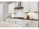 The kitchen features white cabinets, stainless steel range hood, and a cooktop with white subway tile backsplash at 7510 Latteri Ct, Raleigh, NC 27613
