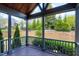Covered porch featuring wood decking, columns, railing, and a view of the landscaped backyard at 7510 Latteri Ct, Raleigh, NC 27613