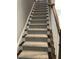 Carpeted stairway with dark wood trim and white risers adds comfort and style to the home's interior at 7510 Latteri Ct, Raleigh, NC 27613