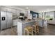 Well-lit kitchen showcases stainless steel appliances, granite counters, a kitchen island with seating, and hardwood floors at 766 Dorset Stream Dr, Fuquay Varina, NC 27526