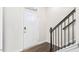 Inviting entryway featuring a paneled front door, wood flooring, and staircase with dark wood banister at 768 Dorset Stream Dr, Fuquay Varina, NC 27526
