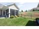 Inviting backyard with screened porch, black fence, and well-maintained lawn and shrubs at 769 Ashley Woods Dr, Gibsonville, NC 27249