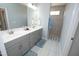 Bright bathroom features dual sinks, grey vanity, and a large shower with window at 769 Ashley Woods Dr, Gibsonville, NC 27249